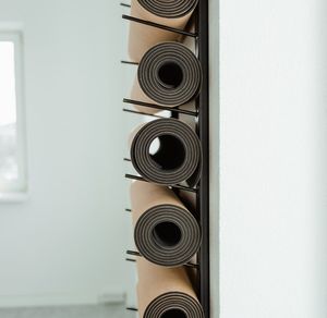 A neatly rolled yoga mat on a wooden floor.
